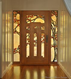 a wooden door with stained glass on the side and stairs leading up to an entrance