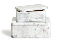 two white marble boxes stacked on top of each other, one with a lid and the other without