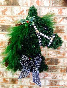 a horse head hanging on the side of a brick wall with christmas decorations around it