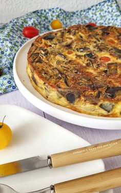 a pizza sitting on top of a white plate next to a knife