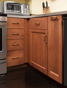 a kitchen with wooden cabinets and stainless steel appliance on the counter top next to an oven