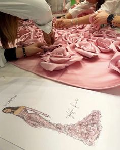 a woman is working on a pink dress