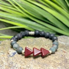 This authentic Native American jewelry bracelet is designed to promote positive energy, making it a meaningful gift for him. It's a thoughtful birthday gift for dad or any man who appreciates rocker-style jewelry with cultural significance. 🪶 𝗠𝗔𝗧𝗘𝗥𝗜𝗔𝗟𝗦 + 𝗗𝗜𝗠𝗘𝗡𝗦𝗜𝗢𝗡𝗦 ❯  8mm Stones, Glass, Silver-plated beads ❯  Heavy Duty Elastic Cording 🪶 𝗦𝗧𝗢𝗡𝗘 + 𝗘𝗟𝗘𝗠𝗘𝗡𝗧 𝗘𝗡𝗘𝗥𝗚𝗬 ❯  BLOODSTONE activates strength and courage and is also a birthstone for March ❯  LAVA is a groun Rocker Jewelry, Rocker Style, Jewelry For Men, Dad Birthday Gift, Jewelry Bracelet, American Jewelry, March Birth Stone, Native American Jewelry, Style Jewelry