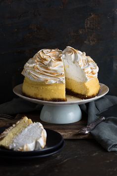 a cake with white frosting sitting on top of a plate next to a fork