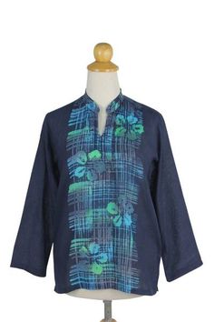 Batik motifs blossom as hibiscus flowers in this stylish deep blue tunic by Chomsuda Samana. Crafted of cool lightweight woven cotton the top features a mandarin collar and slips over the head. The patterns are repeated on the back. Spring Batik Print Relaxed Tops, Spring Batik Print Relaxed Fit Tops, Blue Hibiscus Print Top For Spring, Spring Blue Hibiscus Print Top, Blue Long Sleeve Top With Batik Print, Summer Floral Print Indigo Top, Indigo Floral Print Tops For Summer, Casual Blue Floral Print Tunic, Blue Cotton Batik Print Blouse