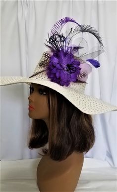 a white hat with purple flowers and feathers