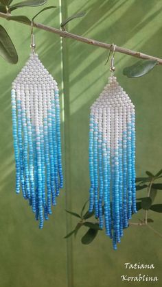 blue and white beaded earrings hanging from a tree branch