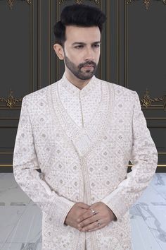 This two-layer sherwani features intricate stones and zardozi, making it perfect for a stylish groom. Step up your traditional attire game with this unique and elegant piece. Traditional Nehru Jacket With Naqshi For Wedding, Kundan Kurta With Naqshi Detailing For Wedding, Wedding Kundan Kurta With Naqshi Detailing, Ceremonial Nehru Jacket With Intricate Embroidery, Festive Formal Lehenga With Naqshi Detailing, Festive Formal Lehenga With Naqshi, Formal Festive Sets With Stone Work, Traditional Wedding Suits With Dabka, Formal Naqshi Lehenga With Traditional Drape