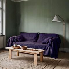 a living room with green walls and purple couch