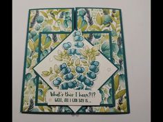 a close up of a card with blueberries and green leaves on the bottom corner