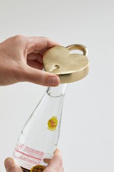 a person holding a bottle with a gold key on it