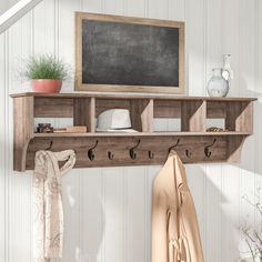 a coat rack with hooks and hats on it next to a chalkboard hanging from the wall