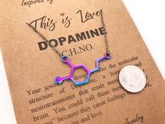 My metallic colorful Dopamine necklace is a cool way to say I love you to anyone that makes your heart happy! Dopamine the neurotransmitter and hormone that causes feelings of pleasure, desire and love. My upcycled Dopamine molecule comes on a matching metallic rainbow plated chain, your choice of length. What a groovy gift! 🔬For other science themed jewelry, please check out my main shop page 👉www.etsy.com/shop/molecularmotifs ✦ PACKAGING ✦ I package each creation in a jewelry envelope with a Multicolor Hypoallergenic Necklace For Gift, Multicolor Hypoallergenic Necklace As A Gift, Hypoallergenic Multicolor Necklace For Gift, Hypoallergenic Multicolor Necklace Perfect As Gift, Rainbow Necklace For Valentine's Day Gift, Dopamine Necklace, Molecule Jewelry, Dopamine Molecule, Psychology Gifts