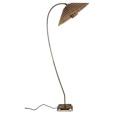 the floor lamp is made from metal and has a brown shade on it's head