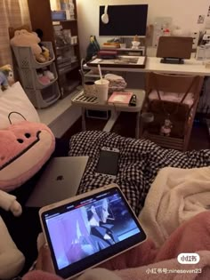 an open laptop computer sitting on top of a bed next to a stuffed animal toy