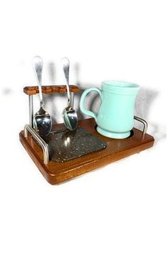 a wooden tray with spoons and cups on it