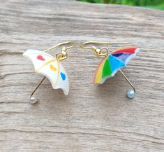 Dainty dangle gold umbrella earrings, a fun novelty jewelry gift idea! Odd mismatched earrings, one is rainbow and one is white with a red blue and yellow heart 💛☂️🏳️🌈 Carefully handmade from resin and gold plated earring hooks, lever back hoops or clip-ons. They are lightweight and you can wear them comfortably all day long.  Sent in a gift box to ensure safe delivery. All packages are sent by priority mail with a tracking number for your convenience and peace of mind. x Handmade in Germany Rainbow Hypoallergenic Earrings As Gift, Rainbow Nickel-free Earrings For Gifts, Nickel-free Rainbow Earrings For Gift, Nickel-free Rainbow Earrings Gift, Adjustable Rainbow Earrings As Gift, Colorful Fun Jewelry Gift, Whimsical Rainbow Dangle Jewelry, Rainbow Single Earring As Gift, Novelty Multicolor Dangle Jewelry