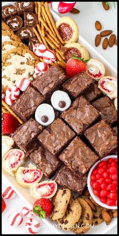 a platter filled with chocolate brownies and candy canes next to pretzels