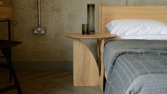 a bed with a wooden headboard and night stand next to it in a bedroom