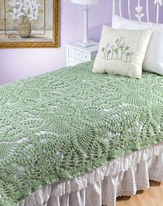 a white bed topped with a green bedspread