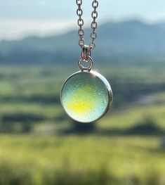 "Genuine sea glass marble in a fine silver bezel set. Hangs on a sterling silver chain 18\". Pendant width: 1.7 cm (0.7 inch) Pendant height: 2.1 cm (0.8 inch) Comes packed in a gift box. Add this adorable piece to your own jewelry collection or make a great gift for a beach lover. Some colours may vary slightly depending on your monitor configuration. If you require any further information please contact me. Thank you for visiting my shop!" Nickel Free Glass Pendant Jewelry, Minimalist Silver Glass Necklaces, Nickel-free Round Glass Jewelry, Glass Cabochon Pendant Jewelry, Silver Sea Glass Round Pendant Jewelry, Turquoise Glass Round Jewelry, Turquoise Round Glass Jewelry, Silver Glass Cabochon Necklace, Nickel-free Silver Necklace Of Recycled Glass