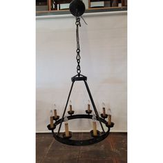 a chandelier with candles hanging from it's center and an iron frame