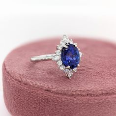 This beautiful ring features a 3.16 carat oval Tanzanite gemstone with a halo of natural earth mined diamonds set in solid 14K gold. This Tanzanite ring makes a lovely December birthstone gift for your loved ones! This ring is made with solid 14K Gold and natural Earth mined SI / G-H diamonds. As listed, this ring is ready to ship. If you're interested in purchasing this setting with a different center stone please message us! Gia Certified Oval Halo Ring, Oval Tanzanite Jewelry With Halo Design, Oval Tanzanite Halo Jewelry, Timeless Oval Gemstone Halo Ring, Timeless Oval Halo Ring With Gemstone, Oval Cluster Ring With Gemstone In 14k White Gold, Oval Gemstone Halo Ring In Fine Jewelry Style, 14k White Gold Oval Halo Ring, Oval Halo Ring In 14k White Gold