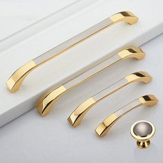 four pieces of gold metal hardware on a white surface