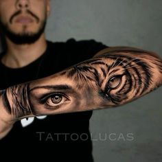 a man's arm with an eye and tiger tattoo on the upper half of his arm