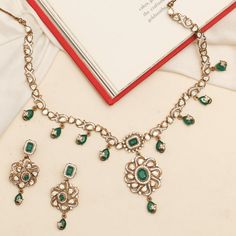 Description: Discover the Maya necklace set, a stunning blend of tradition and modern elegance. Showcasing a moissanite-studded central pendant with a floral design, highlighting an emerald green stone. Adorned with intricate motifs and drop emerald green stones, this necklace adds timeless brilliance and cultural charm to your jewelry collection. Product Information: Metal: 925 Silver with Victorian Plating Length: Necklace- 18cm, Earrings- 5cm Stones: High Grade CZ Stones Findings: Hook & Link Elegant Green Diamond Necklace Hand Set, Traditional Hand-set Emerald Diamond Necklace, Traditional Hand-set Diamond Emerald Necklace, Elegant Green Hand Set Diamond Necklace, Elegant Green Pendant Bridal Necklace, Emerald Jewelry With Stone Work As Gift, Emerald Jewelry With Stone Work For Gift, Traditional Emerald Kundan Necklace For Formal Occasions, Traditional Emerald Necklace With Diamond And Intricate Design