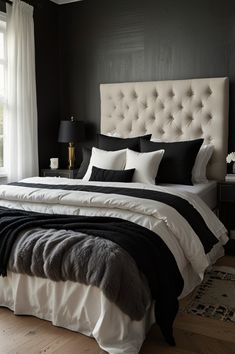 a bedroom with black walls and white bedding in the center, along with two lamps on either side of the bed