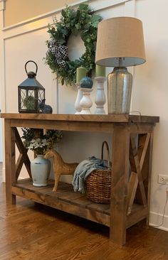 a wooden table topped with vases and a lamp