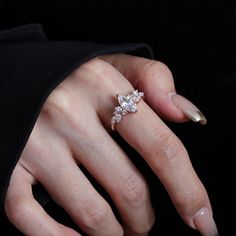 a woman's hand with a diamond ring on her finger and two diamonds in the middle