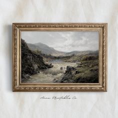 a painting hanging on the side of a wall next to a wooden frame with a river running through it