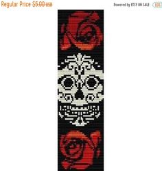 a cross stitch bookmark with roses and a skull on it's back side