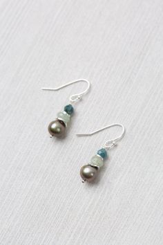 The Resilience Collection, boasts versatile neutral tones that elevate any outfit, all year round. Handcrafted to perfection, these earrings are a charming addition to any wardrobe. Sterling Silver (Lead & Nickel Free) Aquamarine, Sapphire, Freshwater Pearl 1.25" with sterling silver ear wires We hand select our natural materials, thus there may be slight variations in color and/or size that will not detract from the overall aesthetic. Our unique handcrafted designer jewelry for women is made in Simple Earrings, Neutral Tones, Designer Jewelry, Body Oil, Ear Wires, Natural Materials, Aquamarine, Fresh Water, Freshwater Pearls