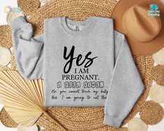 a sweatshirt with the words yes i am pregnant on it next to some straws