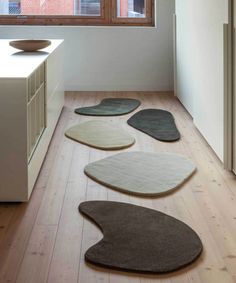 four rugs are arranged on the floor in front of a kitchen counter and window