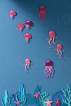 an ocean scene with pink jellyfish and starfish on blue background