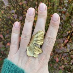 Statement brass gingko leaf ring, Bold rings for her, Adjustable size ginko biloba ring, Unique bohemian jewelry, Gift for plant lover. The ring is crafted based on a real Ginko biloba leaf. It is made of high-quality brass. It features an adjustable size. The band is open, allowing for size adjustments. The size of the leaf is 5.7 cm in height, and the width including the stem, which forms part of the band, is approximately 6 cm / 2.24 inches x 2.36 inches. It fits best sizes US 5-9 / EU 8-20 (48mm -60mm). It can be adjusted to larger sizes by a few more, however, in this case, there may be a gap between the ends of the petal, although it does not prevent wearing the ring. It's a matter of preference. If you know your size, please provide it when placing your order, and we will adjust the Handmade Gold Flower Ring, Nature-inspired, Handmade Gold Flower Ring Nature-inspired, Unique Gold Wing-shaped Jewelry, Nature-inspired Leaf-shaped Brass Jewelry, Ginko Biloba, Bohemian Jewelry Gift, Gift For Plant Lover, Gingko Leaves, Bold Rings