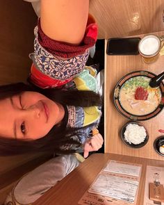 a woman sitting at a table with food on it