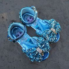 The Perfect Shoes for Your Princess These cute little girl shoes are the ideal piece for any little one who loves to dress up as their favorite princess. Whether they want to feel like the belle of the ball or the princess of the frosty forest, these beautiful blue sparkly kid shoes can transform any outfit into a little girl's fairytale fantasy. The all-over glitter makes these blue sparkly shoes children’s favorites. Plus, they’re comfortable for any age. The soft inserts will have them on the Frozen Inspired Outfits, Elsa Mermaid, Mermaid Dress Girls, Elsa Halloween, Elsa Shoes, Frosty Forest, Frozen Shoes, Disney Princess Shoes, Valentine Cupcakes