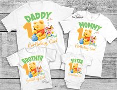 two shirts with the number one on them and a teddy bear holding a baby's first birthday cake