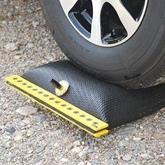 there is a tire on the ground with a yellow leveling strip next to it