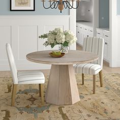 a dining room table with chairs and a chandelier hanging from it's ceiling