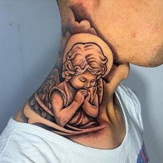 a man's neck with an angel tattoo on it