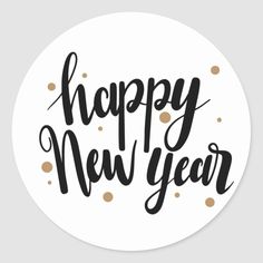 the words happy new year written in black and gold on a white circle sticker