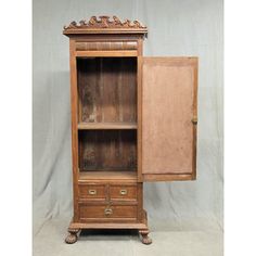 an old wooden cabinet with doors open and drawers on one side, in front of a white background