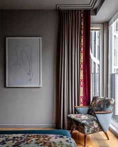 a bed sitting next to a window in a bedroom under a framed art work on the wall