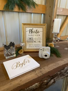 a wooden table topped with glasses and a framed photo next to a sign that says photo guest book